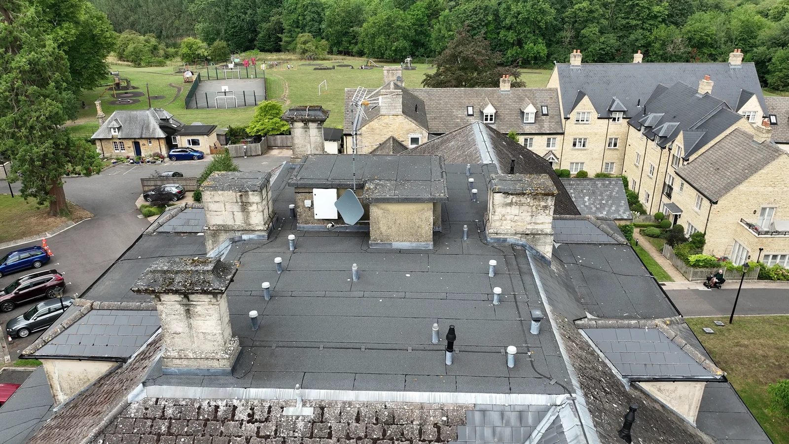 Roof overview showing chimneys, flat roof areas and adjoining tiled slopes