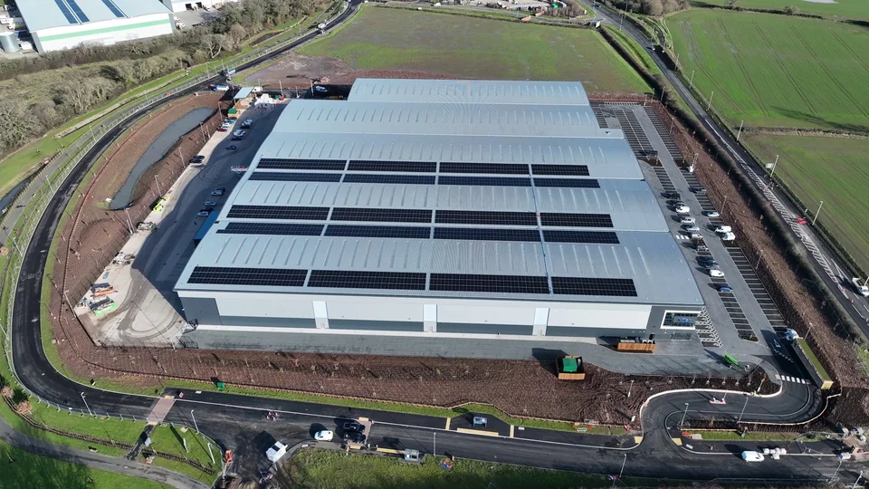 Commercial roof with rows of solar panels and surrounding access roads