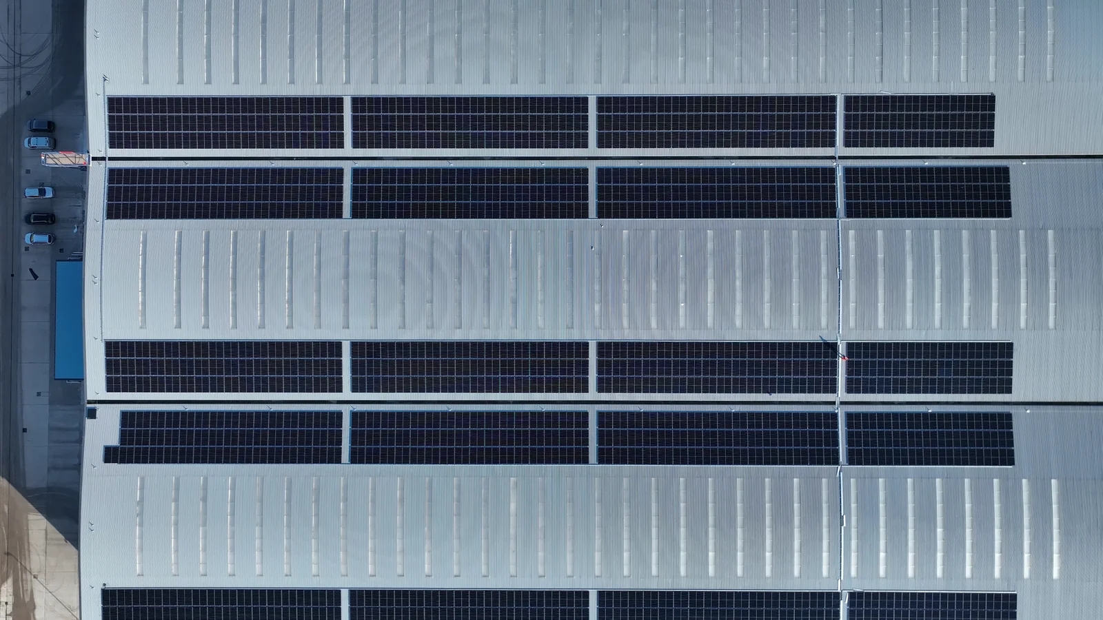 Overhead view of solar panel rows on an industrial roof