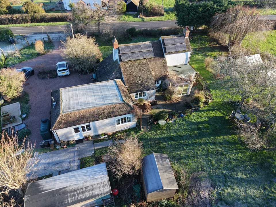 Aerial view of a rural house, adjoining buildings and garden