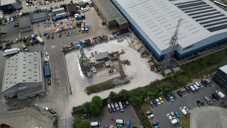 Industrial buildings, yard and parked vehicles viewed from the air