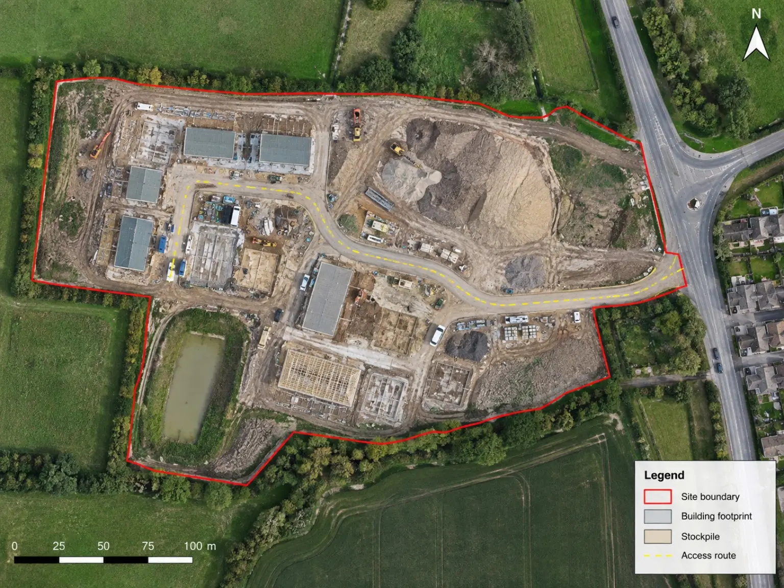 Aerial mapping output of a construction site with the site boundary outlined in red, building footprints, a stockpile, an access route, a north arrow, a legend and a scale bar