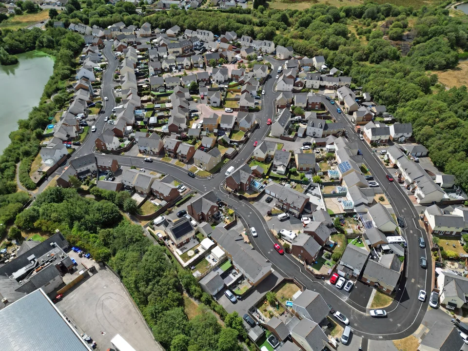 Drone view of residential streets, homes and open green space