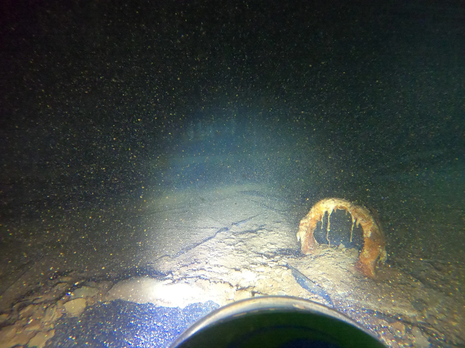 ROV photograph of deposits on a water tank floor and around a submerged outlet