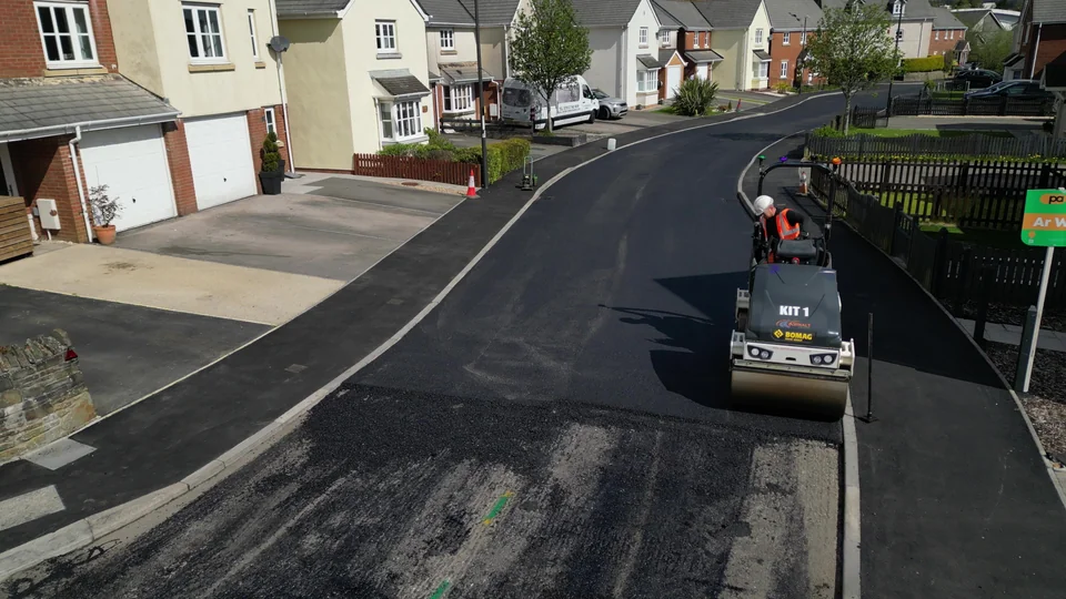 Road roller on newly laid asphalt on a residential street