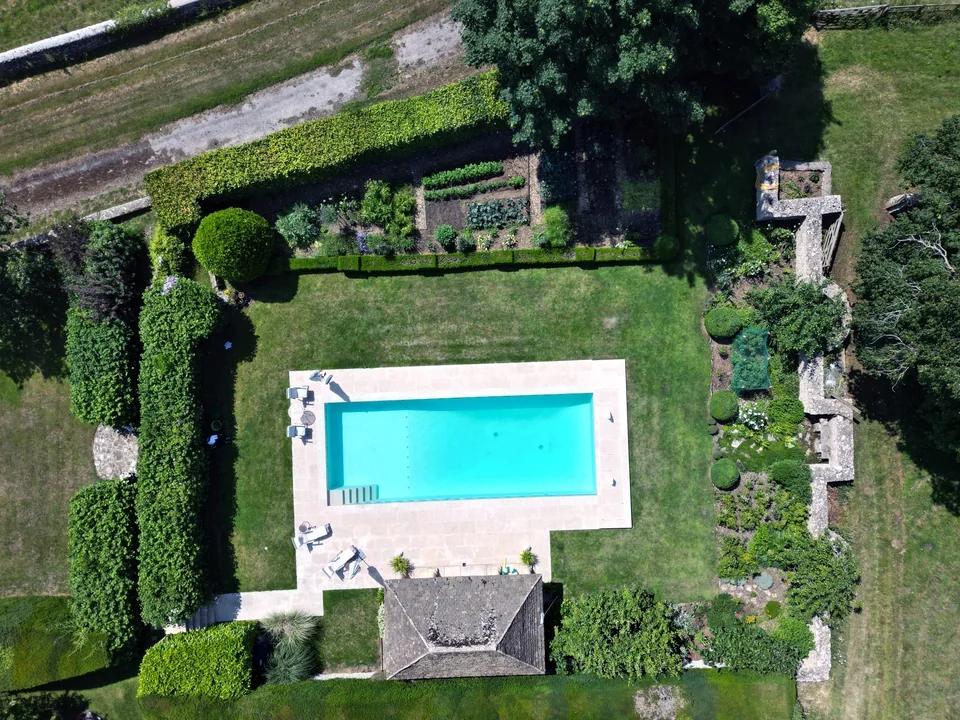 Overhead drone photograph of a swimming pool and walled garden