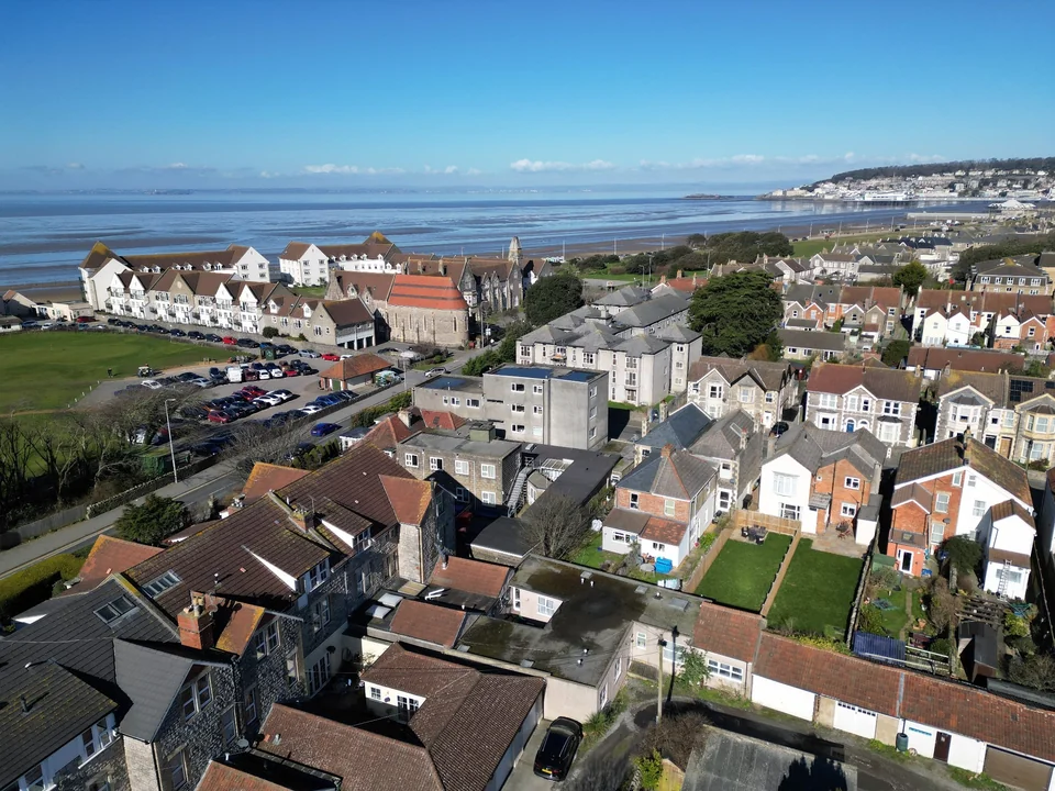 Aerial view of coastal homes with the sea and seafront beyond