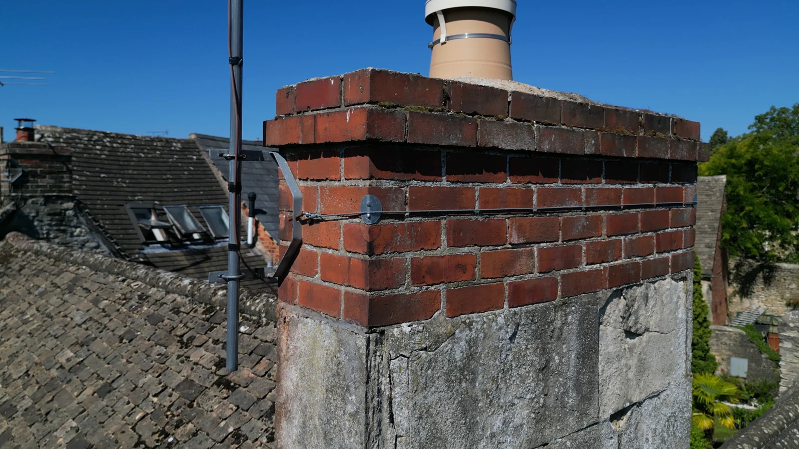 Close aerial view of a brick chimney and television aerial mounting
