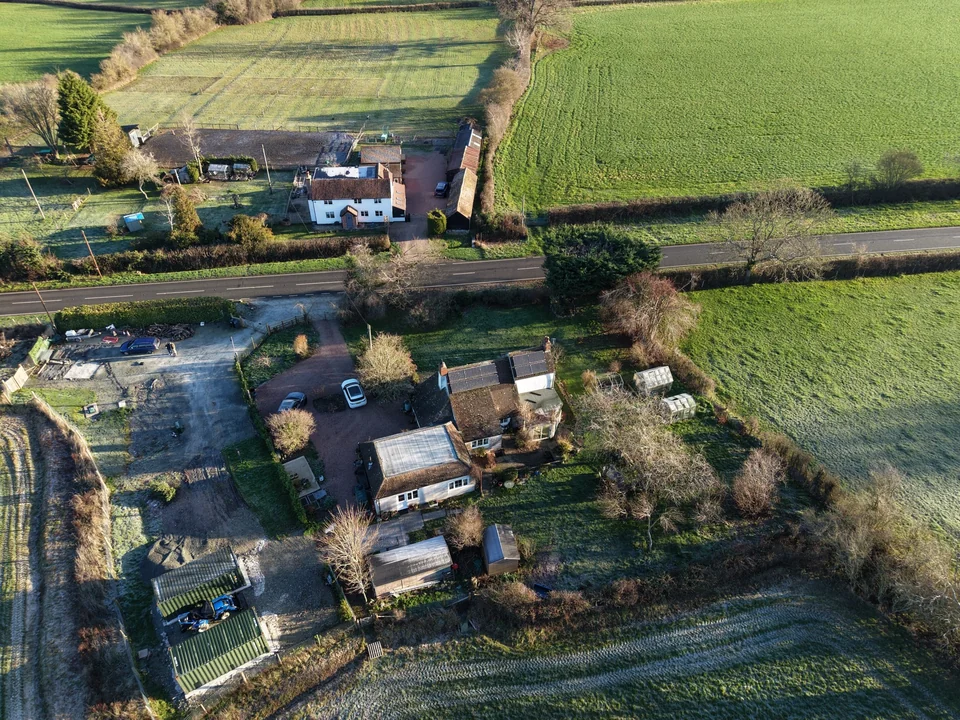 Oblique aerial photograph of rural homes and surrounding fields